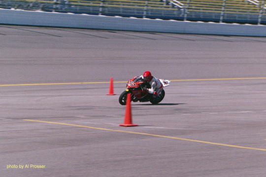 Red and white bike, about to enter turn one, inside shot